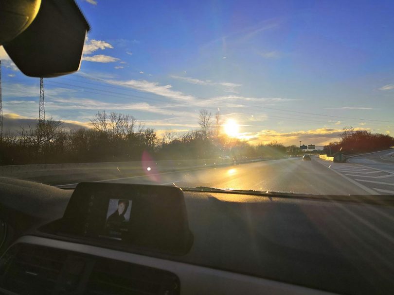 coucher de soleil à travers le pare-brise sur la route